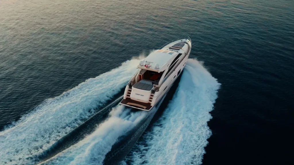 Luxe Princess Yacht vaart met hoge snelheid over een rustige zee bij zonsondergang.