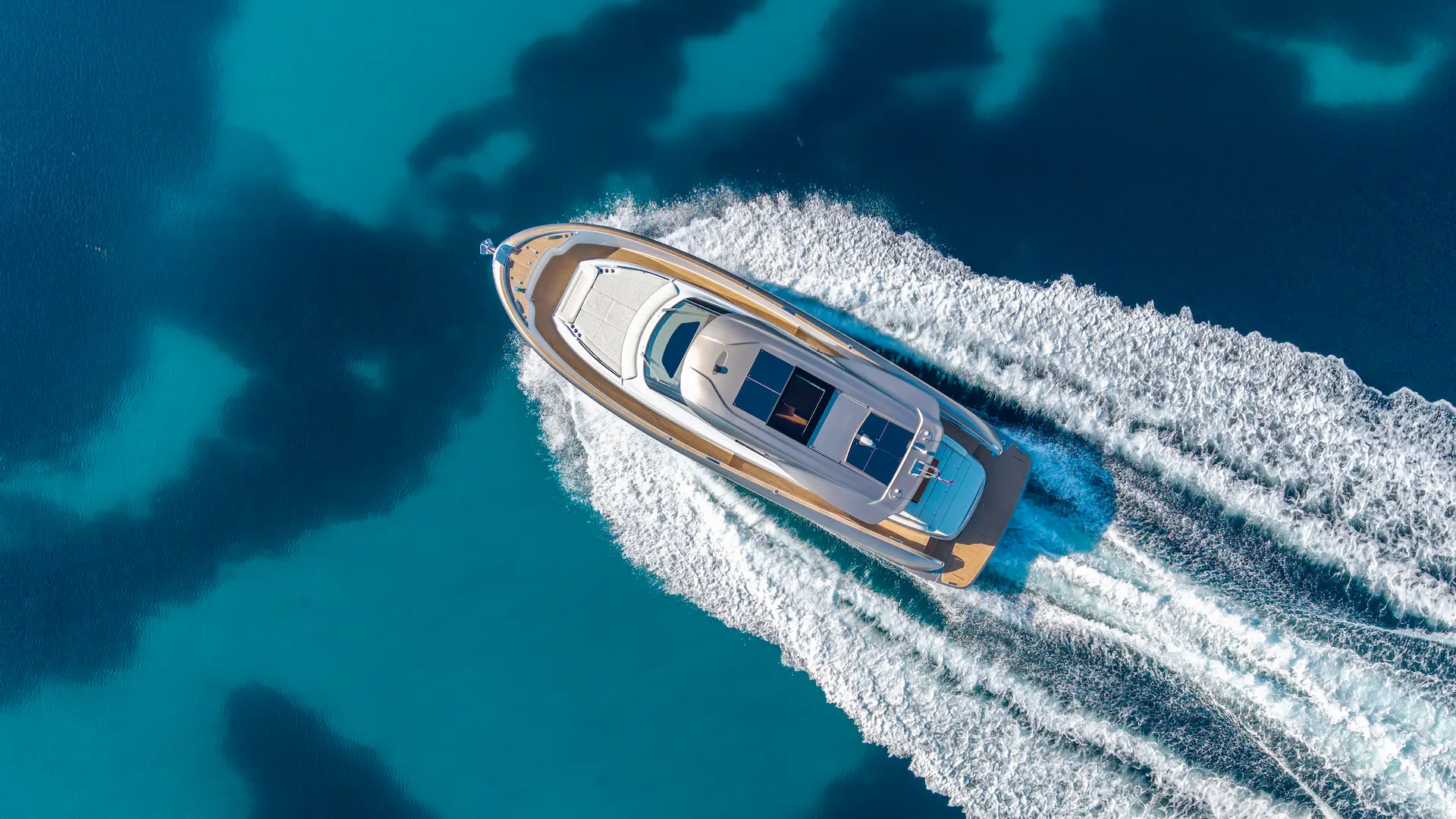 Luchtfoto van de Solaris Power 52 Coupé die vaart over helderblauw zeewater.