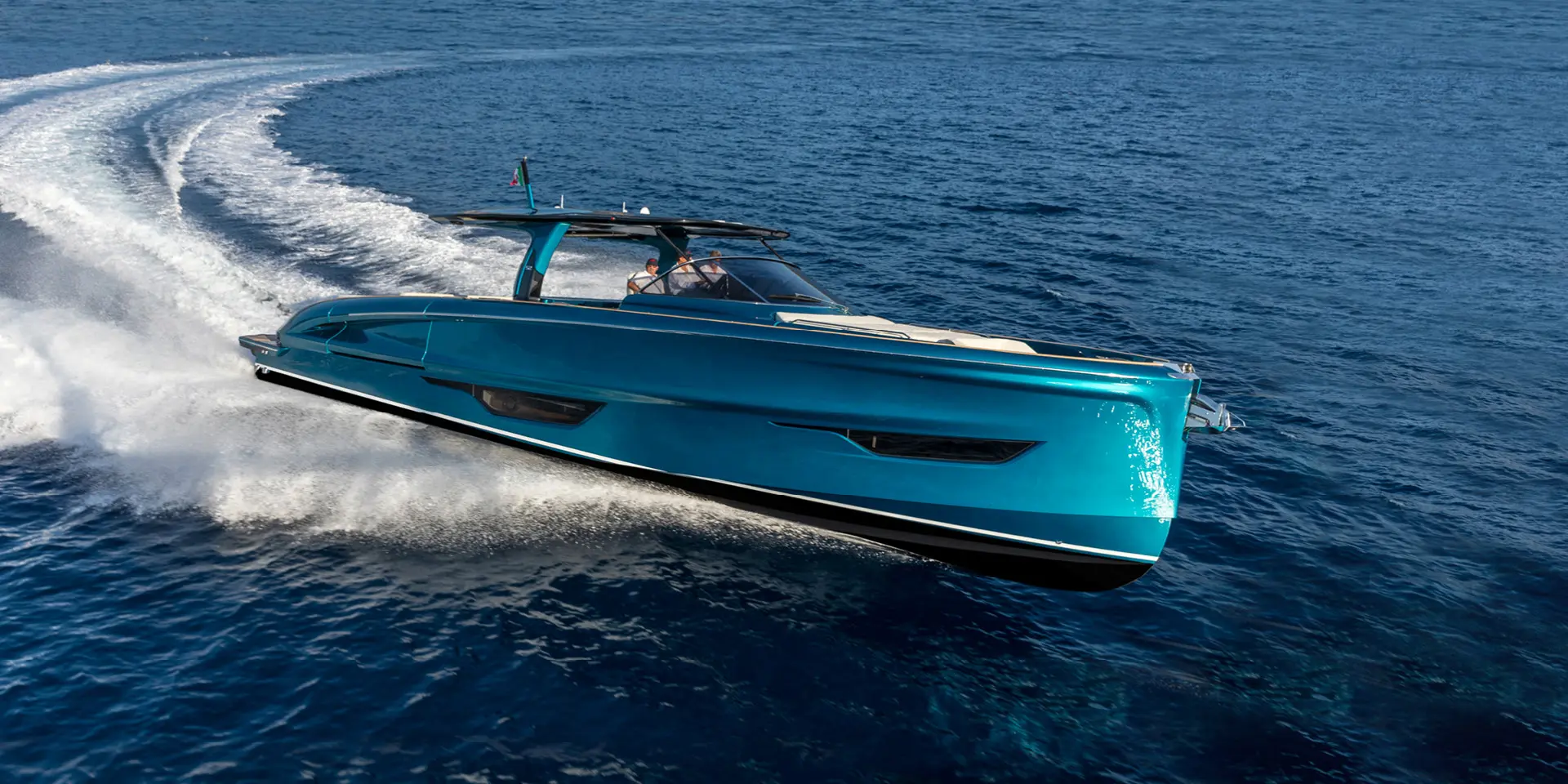 Een blauwe Solaris Power Open Series motorboot vaart op hoge snelheid over een heldere, open zee.